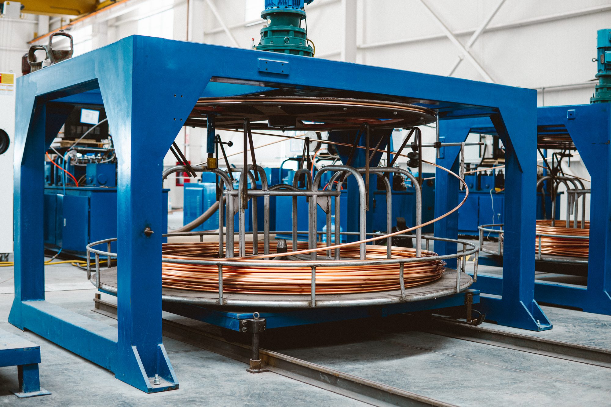 Copper cladding line with coiled copper conductor on a blue forming frame